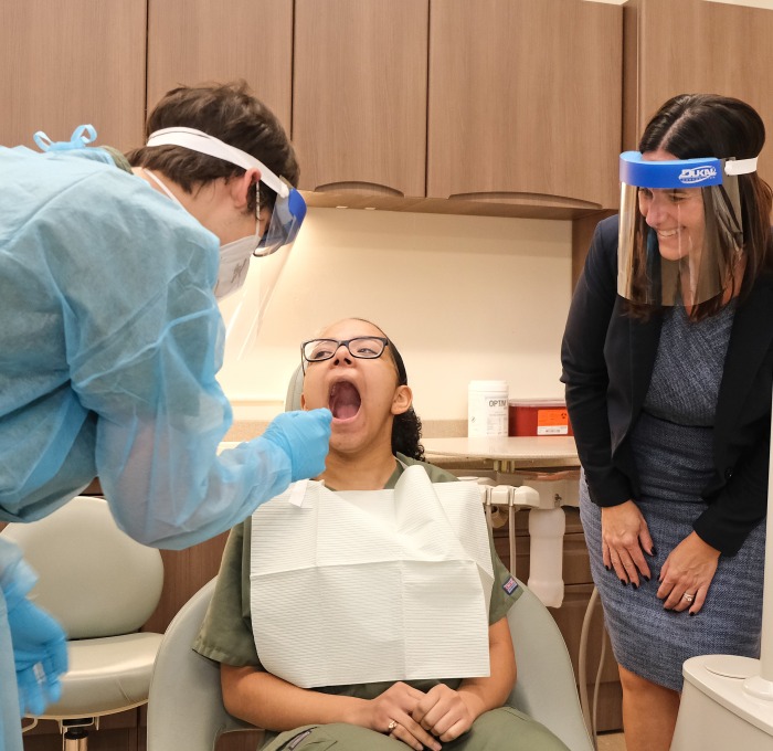 Monty Tech dental classroom students evaluating teeth in dental chair and principal looking on