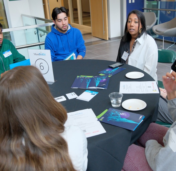 Students and business professionals having discussions around the table