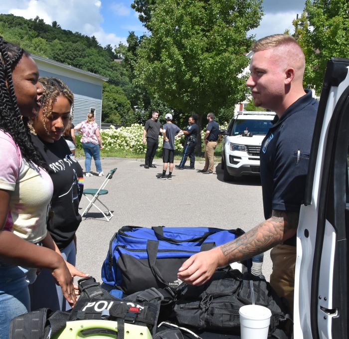 Two female students talking to university police office table at community event