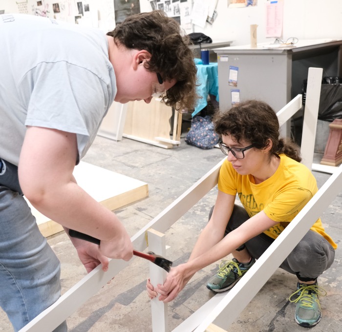 Students building sets in the wood shop hammering boards together