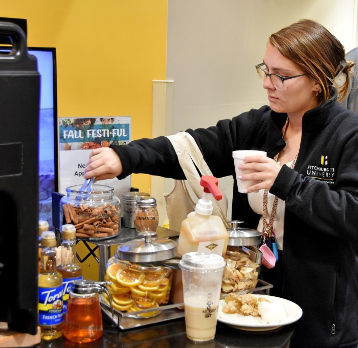 Female student getting beverage in Holmes during fall fest