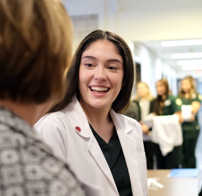 Female student with white coat and professor at white coat
