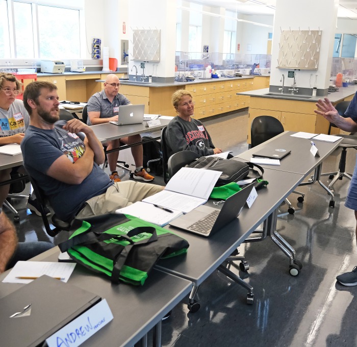 Students listening to professor at front of the class 