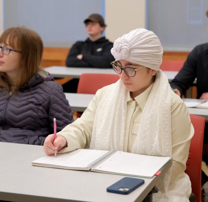 Students listening and taking notes in business management class