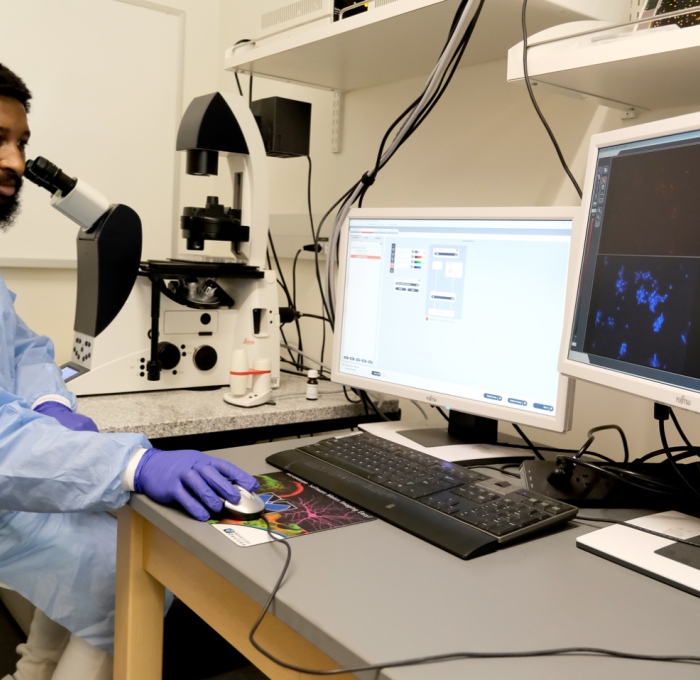 Student working with microscope in science building