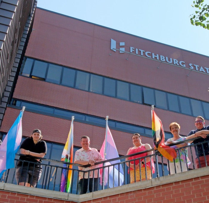 Staff and students raising pride flags in front of Hammond Hall