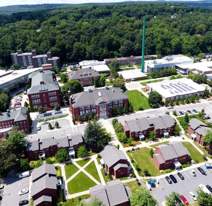 Aerial drone shot of campus buildings from Cedar St facing smokestack