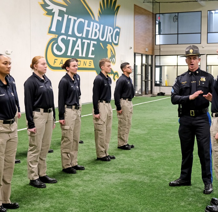 CJ students and instructor in landry standing at attention