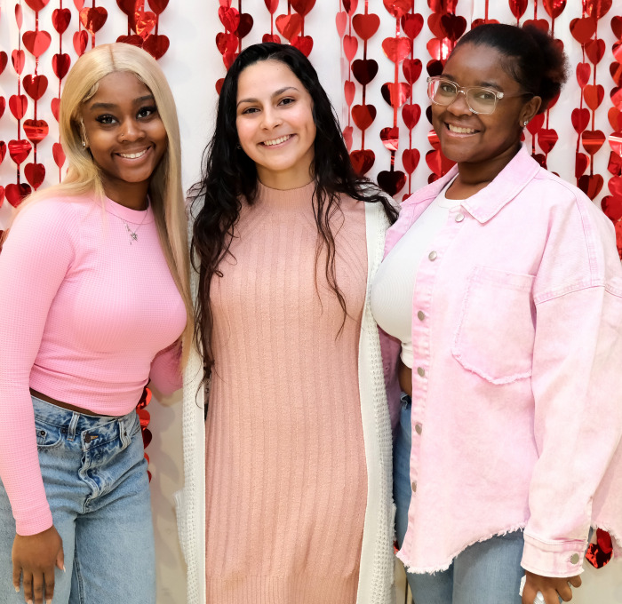 Krysta and student pose with the Valentine backdrop