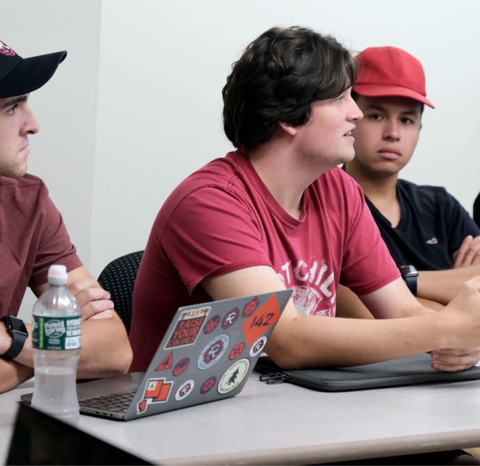 Male students at table in classroom