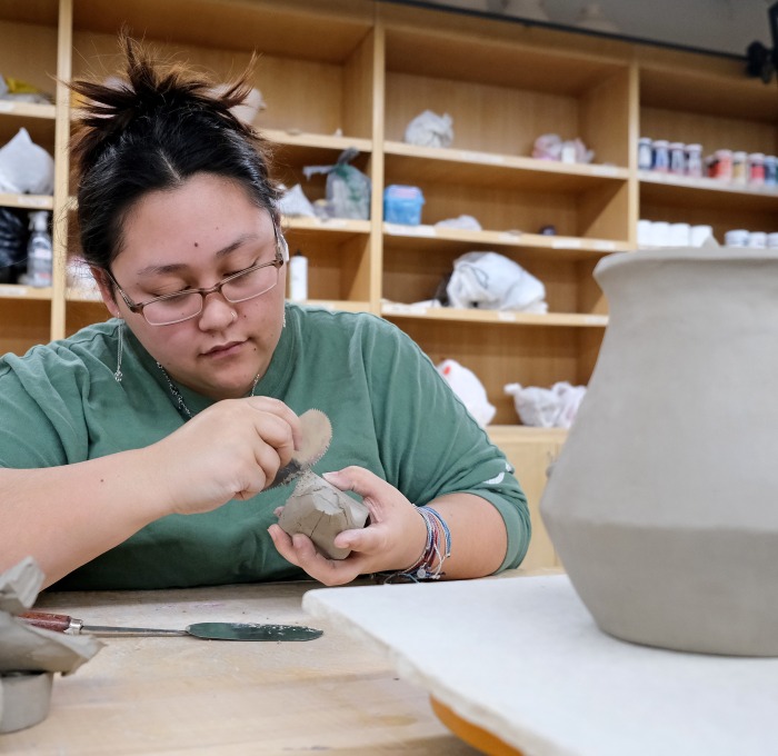 Female student in ceramic class working on pottery