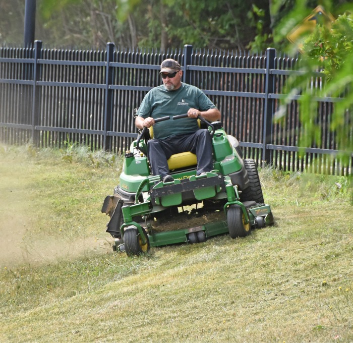 On riding lawnmower cutting grass