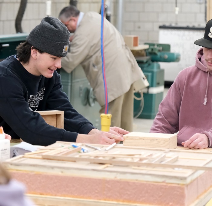 Two males students building and fabricating in an engineering class