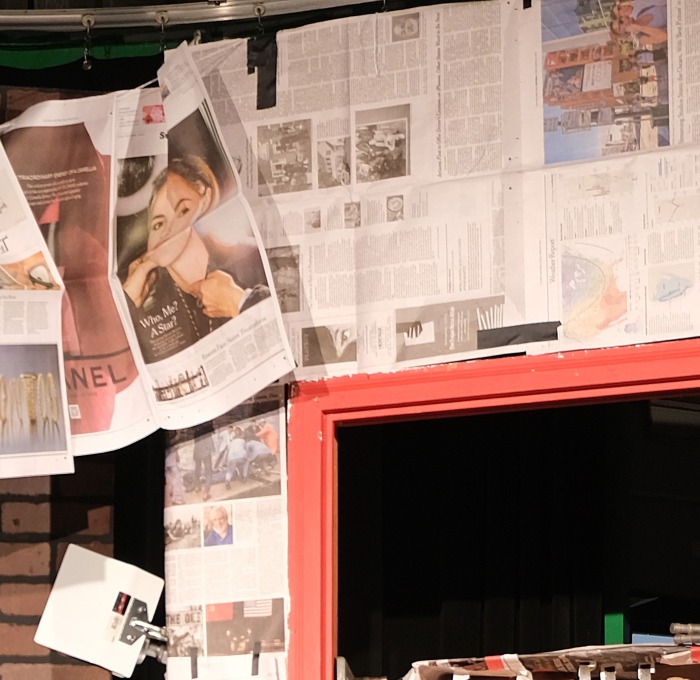 Newspapers hanging against a brick wall