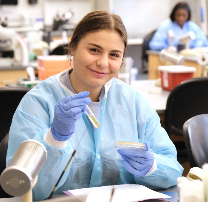 student in microbiology lab with a test tube