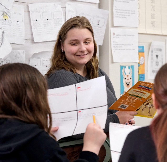 Student teaching at McKay reading to two female students