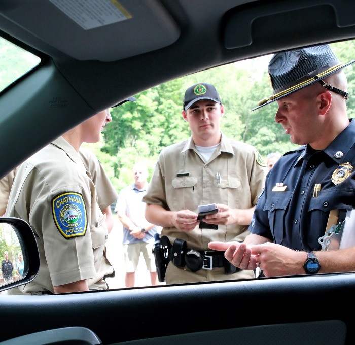 Police and recruits outside car window during a traffic stop
