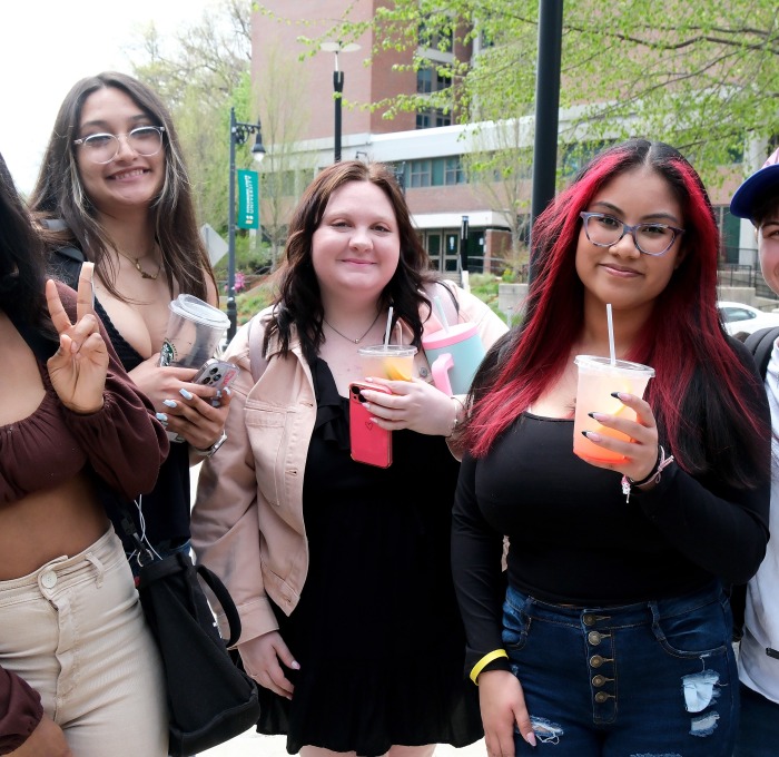 students holding drinks outside in front of Aubuchon hall
