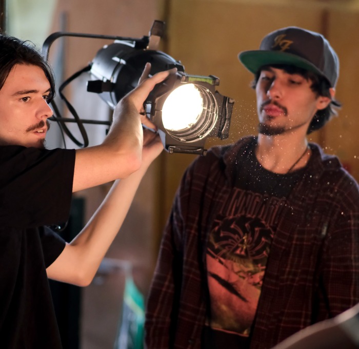 Two students adjusting spotlight 