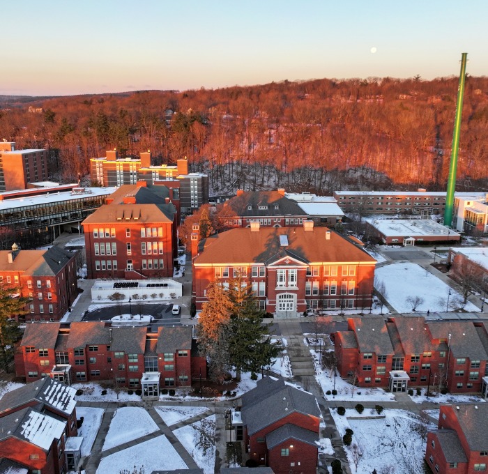 Aerial quad at sunrise in winter with snow on ground and moon in sky