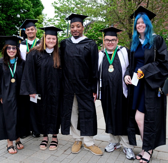 Group of six smiling graduates at undergrad commencement