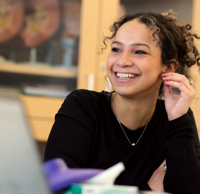 Smiling female student in classroom lab with laptop