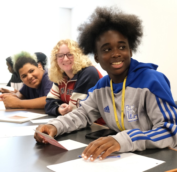Group of upward bound students smiling at table