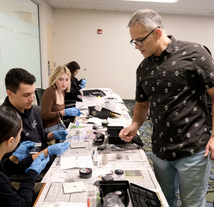 Students working with fingerprinting equipment in CJ class