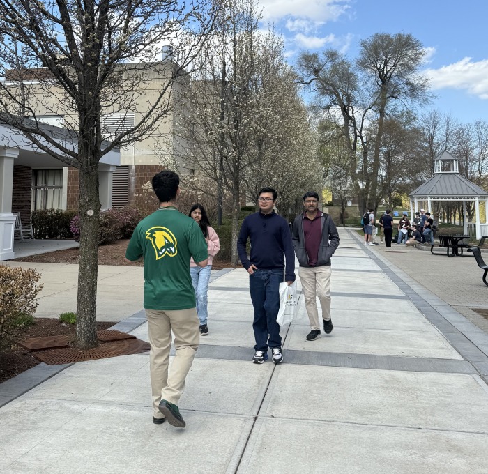 Tour guide and group walking on campus