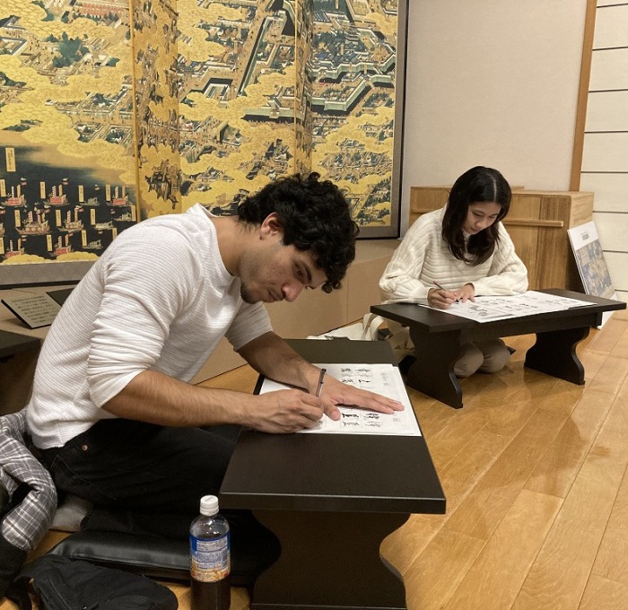 Students sitting at low desks drawing in Japan