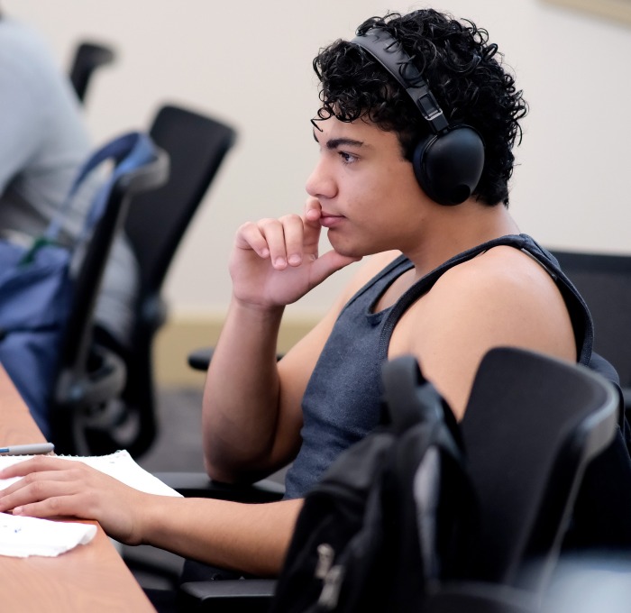 Male student with headphones at computer