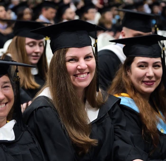 Group of smiling grad students sitting during ceremony