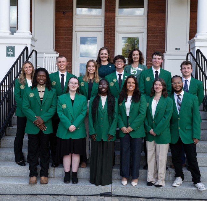 Presidential Ambassadors take photo with Pesident Hodge in front of Thompson Hall
