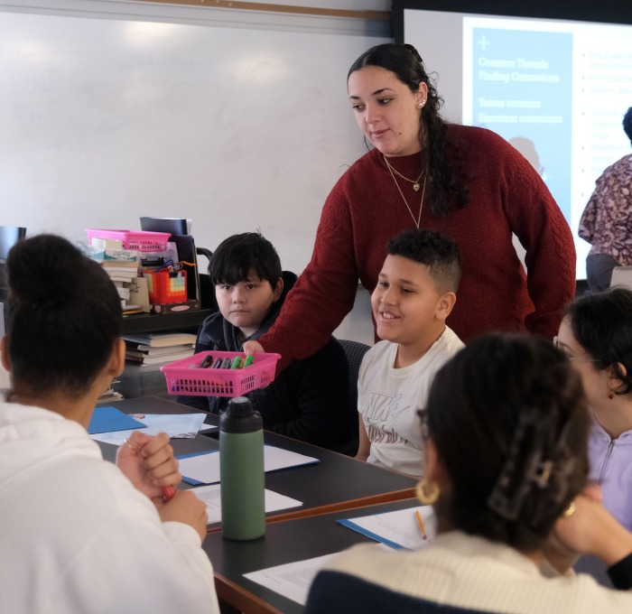 Teacher in classroom with students at tables.