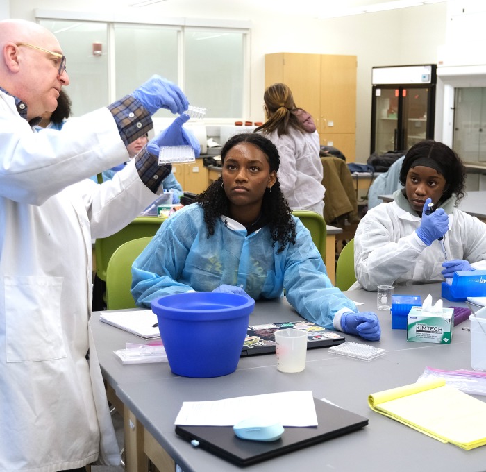 Teacher demonstrating to students how to do the experiment in the lab.