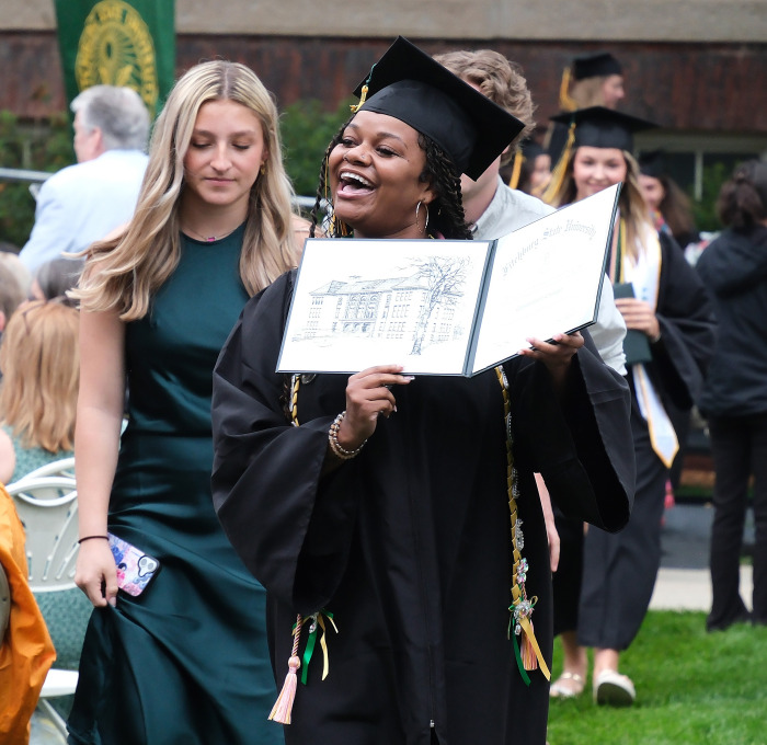Smiling nursing graduate showing her with diploma.