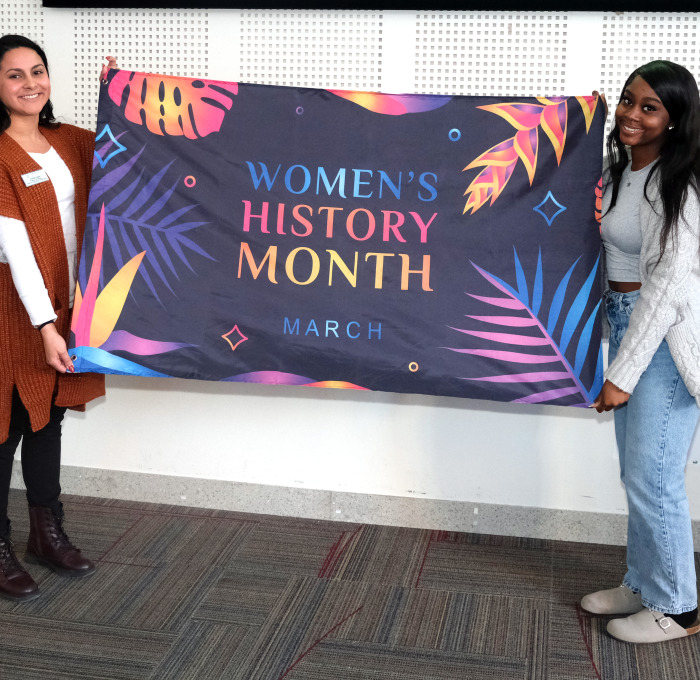 Krysta and student holding flag in Main Lounge.