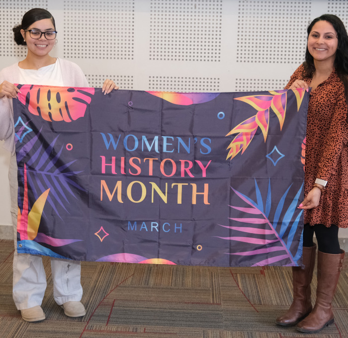 Krysta and student holding flag in Main Lounge.