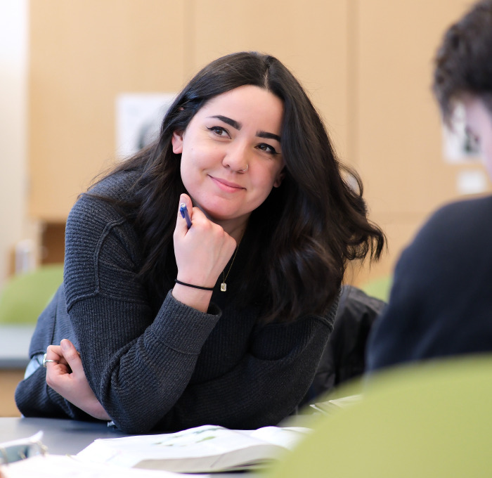 Smiling female student at table in lab.