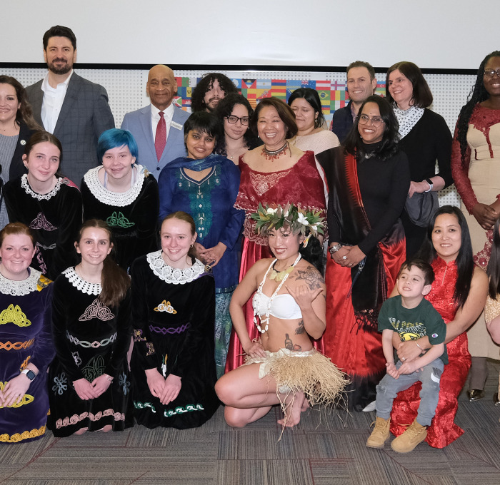International night group photo of staff and students in cultural attire.