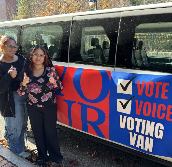 Students giving the thumbs up next to voting van on North Street.
