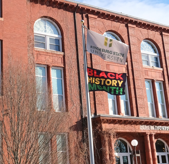 Black History Month flag in front of Thompson Hall in winter. 