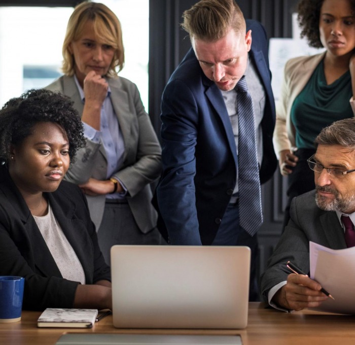 Office workers gathered around a laptop