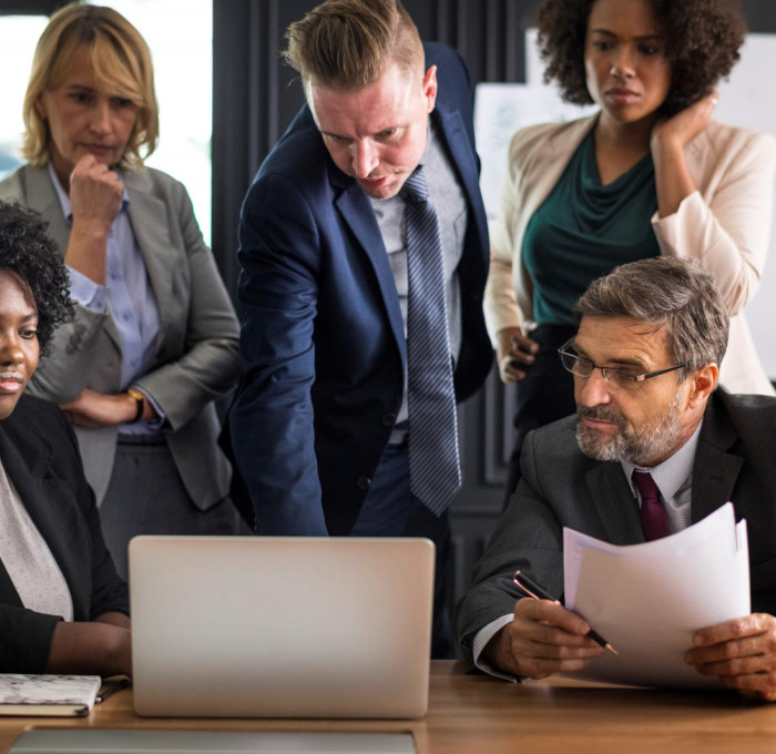 Office workers gathered around a laptop