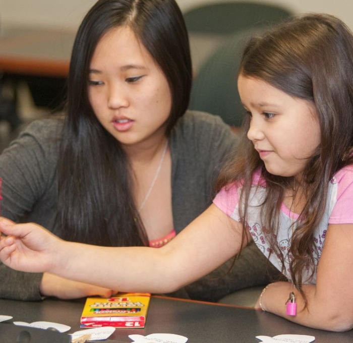 College student teaching a young girl