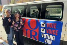Students giving the thumbs up next to voting van on North Street.