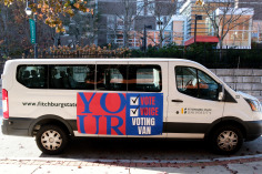 Fitchburg State van with Your Vote, Voice, Voting Van sign on it in front of Russell..