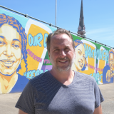 Portrait of alumnus Jon Allen and downtown mural