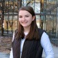A photo of student Miranda Gustin in front of the library