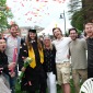 Family celebrates graduate with confetti outside on quad after ceremony